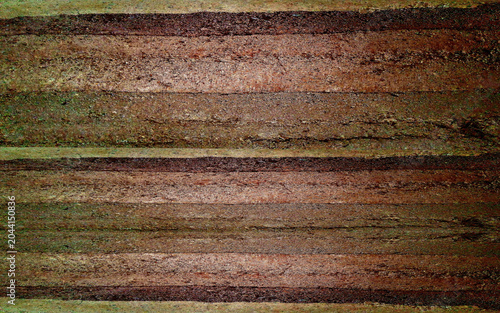 Coarse rammed earth wall texture with heavy dark brown layers