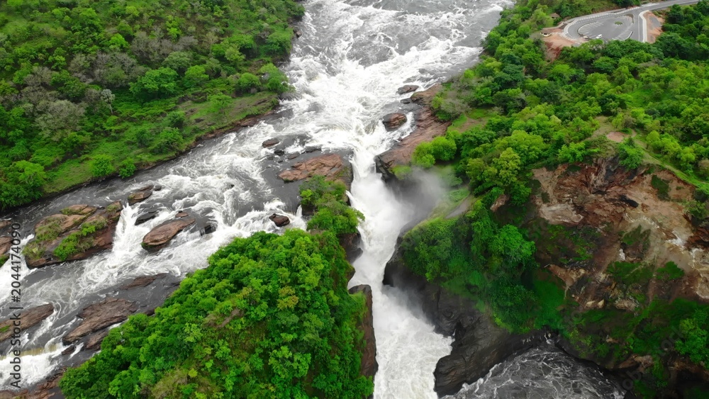 Naklejka premium Aerial View Of Rocky Cascade, Overhead Perspective Of Waterfall With Surrounding Greenery And Mist. Media