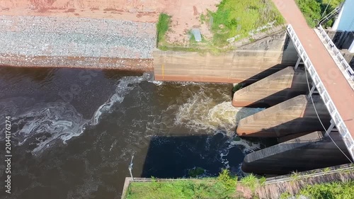 dam on the river, water rushing through concrete dam spillway gates, generating strong currents and white foam for agricultural irrigation management concept