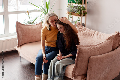 Foto Mother Talking With Unhappy Teenage Daughter On Sofa, Mom supports a sad teen gi