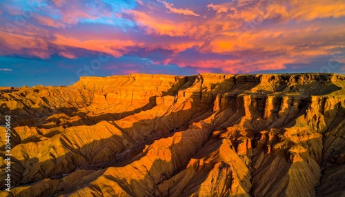 Dramatic sunset over rugged canyon landscape with river.