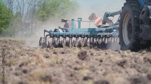 Agricultural Disc Harrow Cultivating Soil on Farm Field