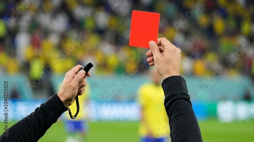 Referee showing red  card and holding whistle during World Cup 