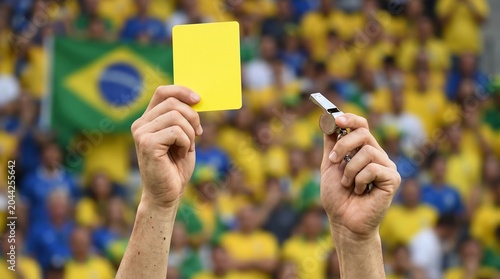 Referee showing yellow card and holding whistle during World Cup 