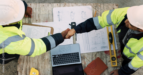 Fotografie Construction, team and architect with handshake outdoor for site handover, legal closure or agreement