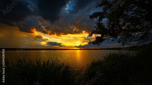 Fotografie Dramatic Golden Sunset Over Dark River
