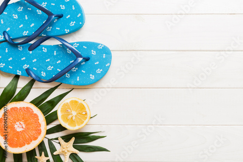 Top view composition of flip flops placed with beach accessories top view on table background. Tropical summer vacation concept Flat lay