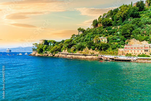 panoramic view of beautiful sea coast with amazing green hills nice antuque buildings and blue water in a sea bay. Ligurian gulf during day or evening.