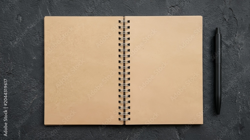 Fototapeta premium Open spiral notebook with pen on dark textured background