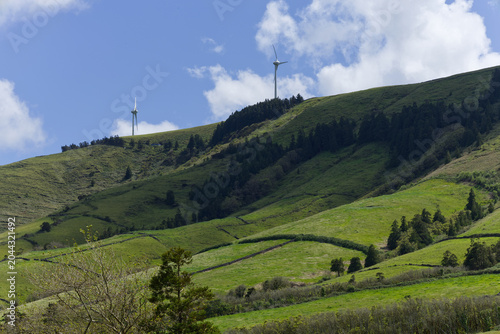 Foto Wind turbines generating clean energy on green hills in azores