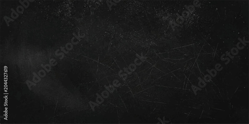 Fotografie A dark, textured chalkboard surface, marked with faint chalk dust and numerous subtle scratches, provides a rustic backdrop