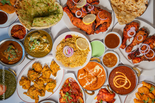 Indian Food Feast assortment flat lay with chicken tandoori curry varieties naan bread and rice