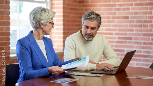 Senior professional designers reviewing color swatches in modern office