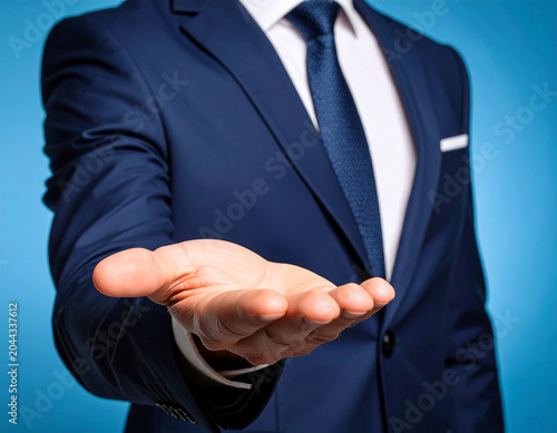 Título: hombre de negocios con traje azul con la mano abierta en gesto de bienvenida, ayuda, acuerdo comercial, confianza, colaboración, oportunidad, apoyo, invitación, cercanía y atención profesional