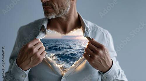 medium close-up of a tired young professional man in a light grey shirt gently pulling open his collar to reveal a glowing miniature ocean scene inside his chest, calm deep blue wa