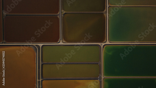 Quadro em tela Down aerial view of rectangular salt evaporation ponds with varying shades of gr