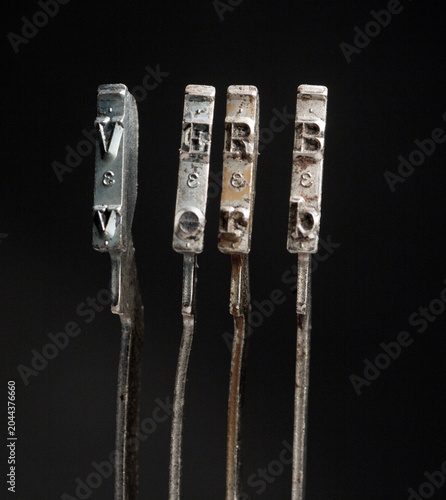The word VERB with vintage typewriter hammers isolated on black 