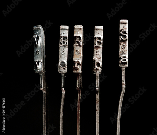 The word verbs with vintage typewriter hammers isolated on black 