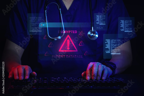 Fotografie Serious medical professional in scrub typing during an alarming healthcare data