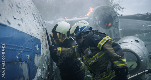 Obraz na plátně Firefighters Pry Open a Torn Airplane Fuselage at a Smoky Forest Crash Site, Using Foam and Tools Near Active Flames as First Responders Race to Reach Survivors in a Breaking Aviation Rescue