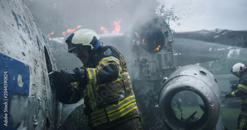 Bilde på lerret Firefighters Pry Open a Torn Airplane Fuselage at a Smoky Forest Crash Site, Using Foam and Tools Near Active Flames as First Responders Race to Reach Survivors in a Breaking Aviation Rescue
