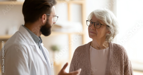 Doctor consulting elderly woman in clinic