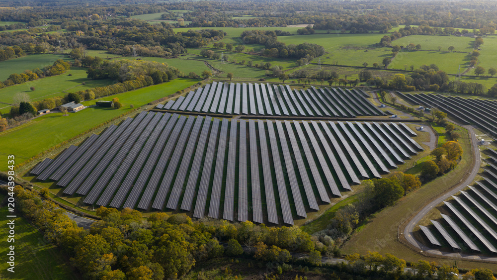 Fototapeta premium Solar farm generating renewable energy in rural landscape