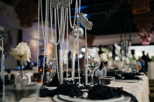Luxury banquet hall table centerpiece with cascading pearl strings and white roses