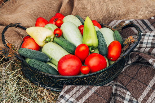 Basket with fresh colorful vegetables and salad on gray wood