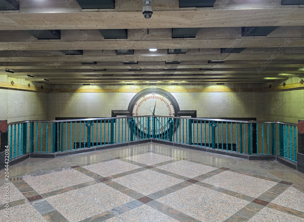 Φωτογραφία Symmetrical transit station interior with large clock and modern architecture