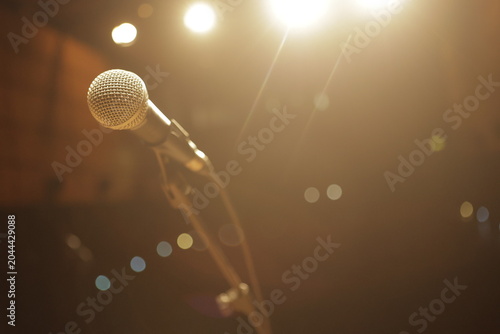 Bild auf Leinwand Microphone on stage awaiting performer under warm lights