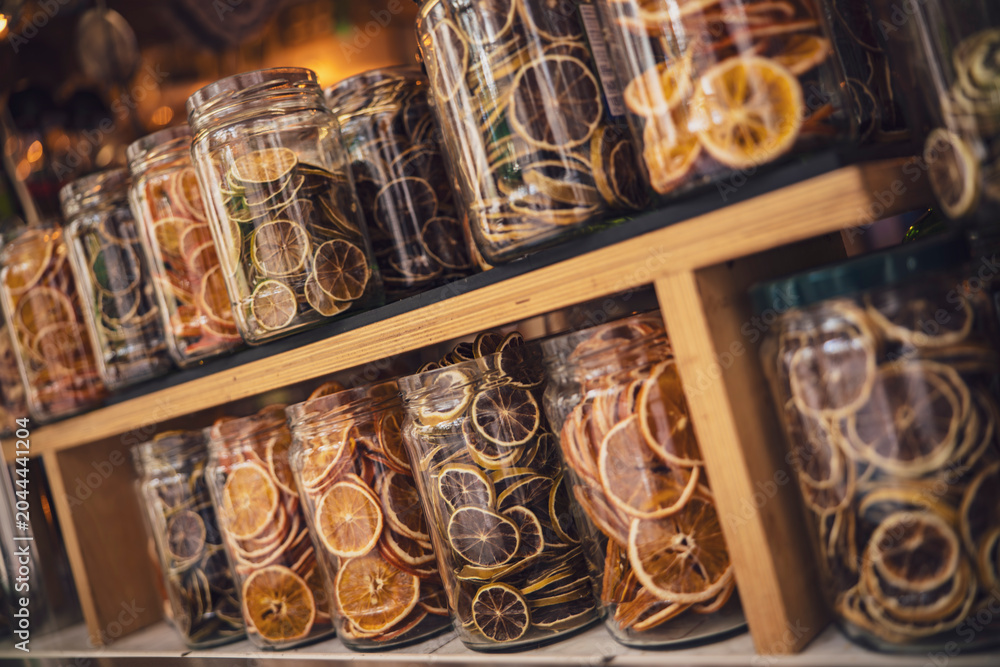 Ταπετσαρία Dried citrus fruit slices preserved in glass jars displayed on wooden shelves