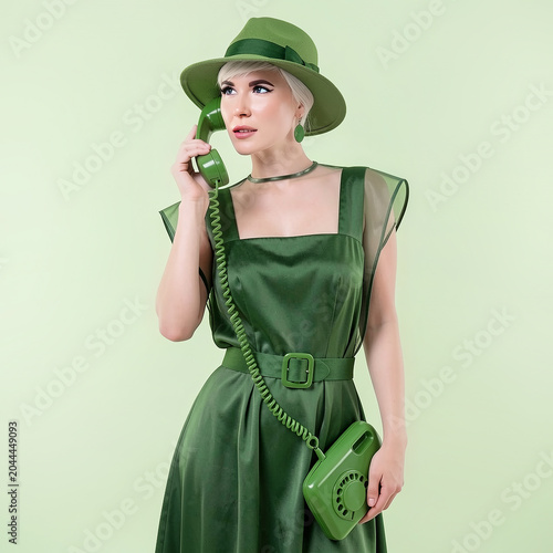 Retro Woman in green dress Talking on Vintage Telephone