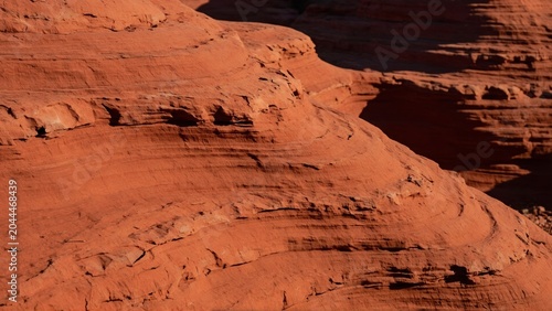 Layered red sandstone formations in desert sunlight