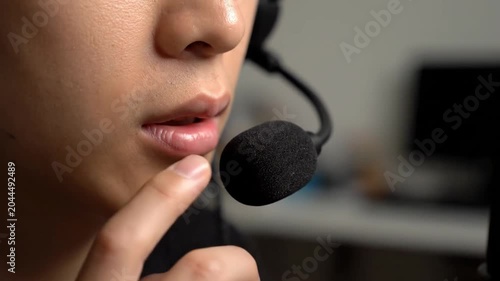 Close up of a customer service representative speaking through a headset microphone in a modern office setting.