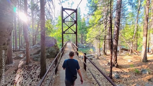 Man Hikes Across Suspension Bridge Over Kings River in Cedar Grove area of Kings Canyon National Park