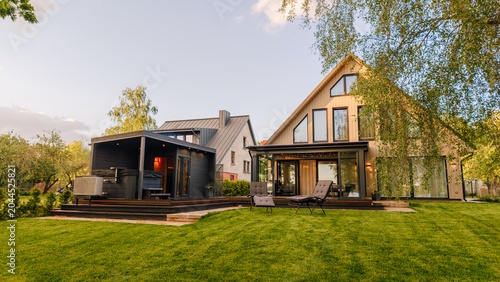 Bild auf Leinwand Modern residential houses with large windows and wooden decks situated in a gree