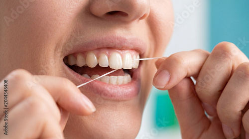 A woman flosses her teeth. Brushing your teeth. Beautiful smile, oral hygiene, oral and dental care, smooth dentition, smile area, interdental space cleansing