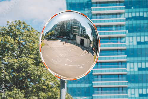 Foto Convex mirror providing a wide angle view of a city intersection, reflecting a c
