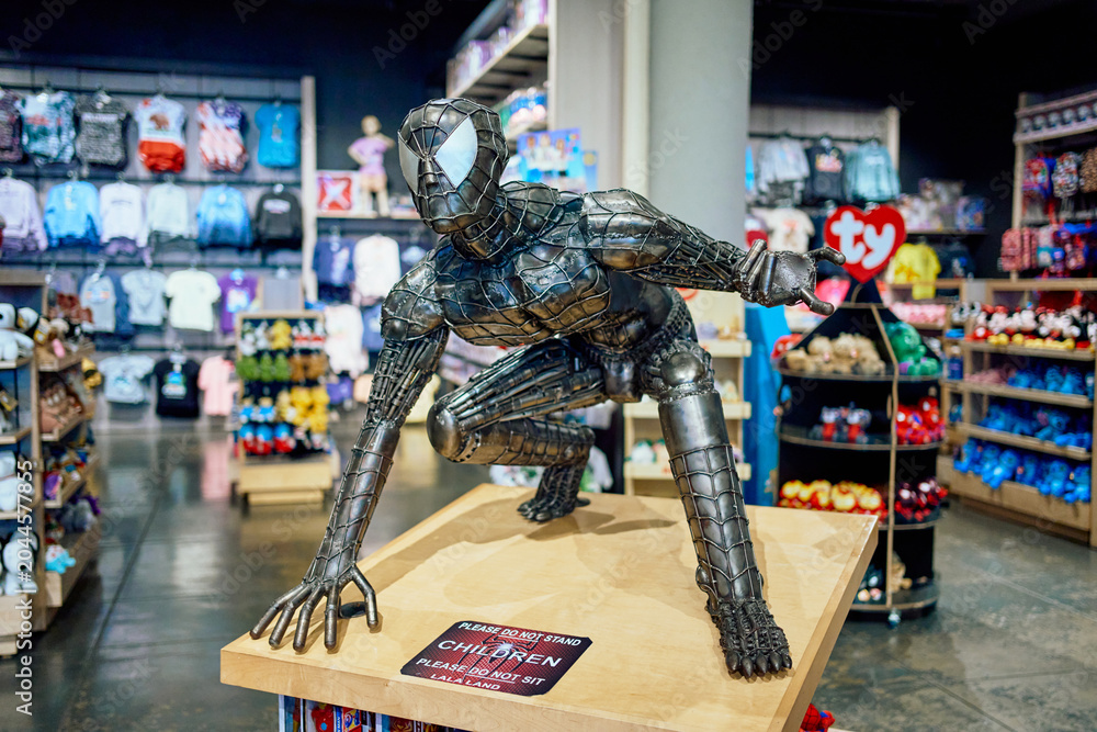 Fototapeta premium Metallic custom Spider-Man sculpture made of welded metal parts on a display stand inside a toy store.