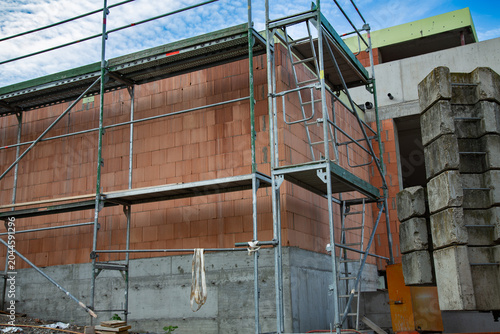 Schilderij op canvas a professional construction site with metal scaffolding next to a new brick wall