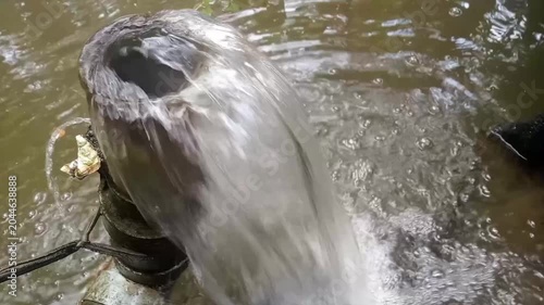 Clean water gushing out from an irrigation pipe into a pond