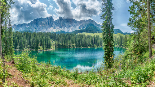 фотографія The emerald green Lake Carezza reflecting Latemar mountain, Dolomites, Italy
