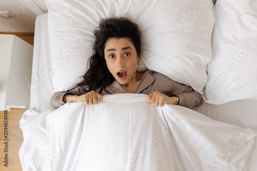 фотографія Above view of stressed woman with shocked face looking at camera, lady in panic