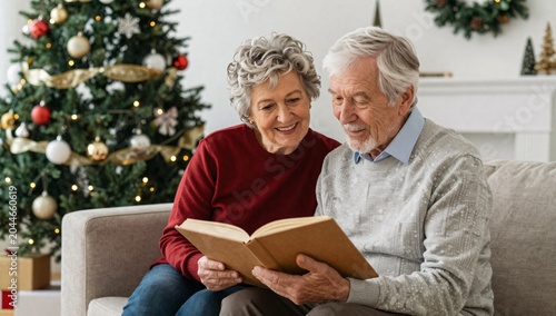 Senior couple sharing memories and looking at an album with christmas tree in background