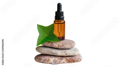 Amber glass dropper bottle on stacked spa stones with green leaf