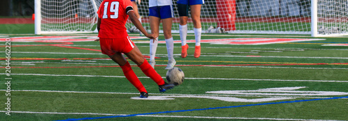 Fotografi Soccer player in red uniform taking a penalty kick during a game