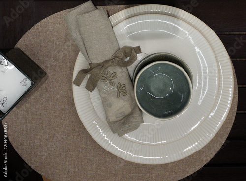 Vászonkép Tableware is arranged on a dining table with plates, bowls, glassware and linen accessories
