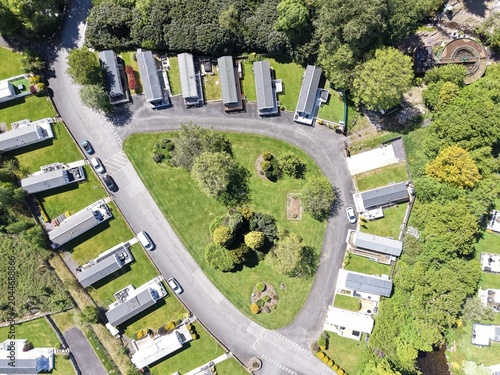 Drone view across rural caravan area with open fields and soft daylight