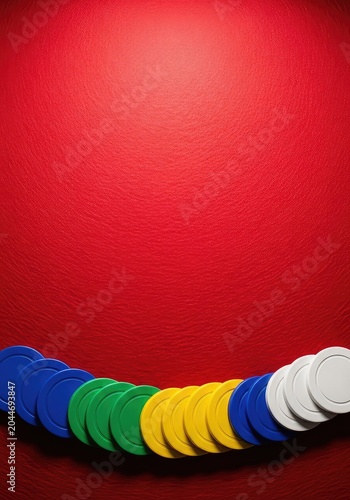 Top down view of a deep red textured felt surface featuring various unmarked colorful betting chips neatly arranged along the bottom border, row, color, deep